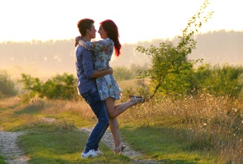 Young couple demonstrating their affection for each other in a sunlit meadow